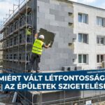 Épület homlokzatának hőszigetelése grafitos szigetelőlapokkal és állványzaton dolgozó munkásokkal.